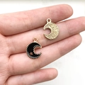 Golden and black enamel crescent moon jewelry pendants with gold stars shown on hand - Black Celestial Moon