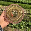 Detail of a golden metal wall decor with filigree patterns and pink crystal accents - Gold Pink Rhinestone