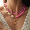 Primer plano detallado del collar en capas con colgantes de tortuga, estrella de mar y concha - Juego de 3 Collares Rosas / Rosa/Dorado/Blanco