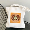 White canvas tote bag featuring bohemian sun and moon mystical print on a chair - STD438-G (Orange Yellow Mystic Sun Moon)
