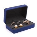 Dark blue velvet jewelry organizer box with rings and earrings inside shown at 45-degree angle - Blue