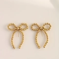 Elegant gold beaded bow earrings featuring a polished metallic finish and dangling tassels - Gold