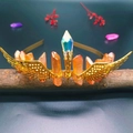 Detail of golden crystal crown featuring orange columns and hollow wing accents on wood - Milk Tea Crystal + Gold Wings