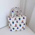 Close-up of quilted cotton tote bag with cartoon bear patterns and Simple Wish label - Blue Overalls Bear Small Handbag