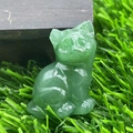 Green natural stone cat figurine in a cute tilted head pose on artificial grass - Green Aventurine