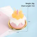 Roze hars cake sleutelhanger met witte crème, gele kersen en een kleine kaars bedel - D01 Gele Kers