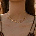 18K gold-plated pig nose link necklace worn by a model in warm natural light setting - 18K Gold
