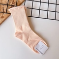 Detailed view of pink ribbed cotton blend crew socks with rolled cuff and brand tag - One Size / Nude Pink