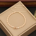 Close-up of bohemian beaded bracelet with natural pink stones, pearls and golden beads - Champagne
