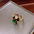 Macro shot of French vintage gold ring with green zircon and black enamel detailing - Gold Vintage Green Gemstone Style