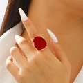 Macro detail of irregular gold-edged ring with deep red enamel on a model's finger - KC Gold Red