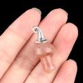 Pink crystal mushroom pendant with silver witch hat detail held in hand - Gun Black Cap / Strawberry Quartz