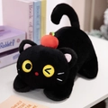 Peluche gatto nero con accessorio mela rossa, posa sdraiata ed espressione che fa l'occhiolino - Nero
