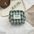 Detailed view of a green checkered pouch featuring a vintage fabric label and metal zipper - Square Sanitary Bag / Green