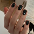 Glossy black short square fake nails on a hand with a cream knit sweater background - Black (JP2641)