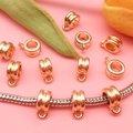 Detalle macro de conectores de dijes de metal dorado KC en una pulsera con adornos - 11631 / 6*10mm / Oro KC
