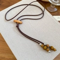 Detail of vintage bohemian wax cord necklace with wood beads and silver metal accents - Necklace-Coffee