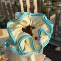 Light yellow ruffled scrunchie with blue wavy trim and decorative valuable tag - Blue-Green Trim Cream White Scrunchie with Red Button
