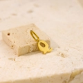 Close-up of golden letter Q pendant on a natural stone base with minimalist aesthetic - Letter-Q / Steel