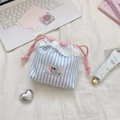 Close-up of drawstring bag with heart lace trim and colorful embroidery on striped fabric - Blue Stripes