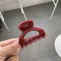 Detailed view of glossy burgundy butterfly hair claw clip with smooth curved design - Ancorra Red