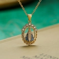 Gold plated Virgin Mary pendant necklace with blue zircon and pearls on a book background - Blue Zircon Oval Virgin Mary