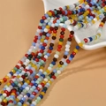 Cuentas de vidrio tallado de 4mm en varios colores saliendo de un cuenco de cerámica blanca - Mezcla de Colores Cristal Opalo