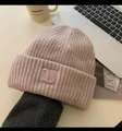 Bonnet en maille épaisse rose pâle avec texture côtelée et écusson sur fond chaleureux - Style Brodé avec Logo L / Rose