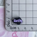 Macro shot of black resin Lucky charm next to a ruler for DIY craft sizing - 05*Black Purple Lucky Cloud Mini