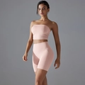 Detailopname van roze naadloze yogaset met bandeau-top en strakke korte fitnessbroek - S / Oudroze