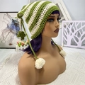 Detail of hand-knitted cat ear hat with green and beige stripes and white pom-pom ties - Green Beige Pom Poms Stars