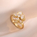 Detailed view of rotating golden flower ring with sparkling zircon stones on soft fabric - Refined Rotating Flower Ring (J0308)