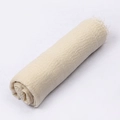 Beige crinkle cotton scarf with fringe tassels rolled up on white background - Beige