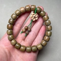 Groene sandelhouten kralenarmband met een gesneden pruimenbloesem hanger - 8x9mm Tonkralen 23 stuks Met Pruimenbloesem Hanger