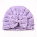 Close-up of purple knit baby hat featuring detailed stitch texture and a large bow - Purple