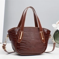 Detailed view of dark brown faux crocodile leather texture and gold hardware on handbag - Brown