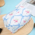 Quilted white cosmetic bag featuring blue bows and pink rose pattern with top zipper - Blue Rose Plaid