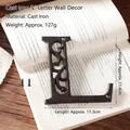 Retro cast iron letter L wall decor featuring vintage scrollwork and mounting screws - Letter L
