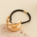 Close-up of golden hammered metal charms on a black elastic hair tie for styling - Lava Hammered Double Layer Hair Tie / Gold