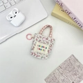 Mini-tasje met bloemenprint en roze geruit handvat op een bureau in lifestyle-stijl - Roze