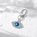 Close-up of a silver evil eye charm with blue enamel and sparkling rhinestone details - Silver Exquisite Rhinestone Evil Eye