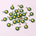 Scattered view of small golden daisy charms with green petals and yellow cores for DIY - Green & Yellow