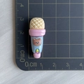 Detailed view of a 3.5cm miniature blue toy microphone with brown bear design on a cutting mat - Bear Microphone