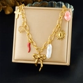 Detail of gold plated necklace with cross, sun, and bow pendants on jewelry display - Bracelet (N3753)