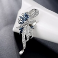 Elegant silver flower brooch with sparkling blue gemstones and crystals on white porcelain - Blue Ribbon Flower