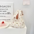 Detail der gesteppten beigen Handtasche mit süßen Bärenmotiven und rot-weißem Futter - Hündchen Bär