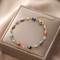 Macro detail of gold Hamsa Hand bracelet with colorful evil eye charms and pearls - Colorful Evil Eye Bracelet