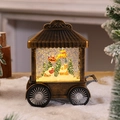 Detalle de linterna navideña vintage tipo carrito con Papá Noel y purpurina brillante - Casa de Navidad de Bronce