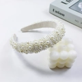 Elegante diadema acolchada con perlas blancas sobre un fondo blanco minimalista - Estilo 1