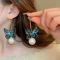 Boucles d'oreilles dorées avec pendentifs papillon bleu et perles portées par un mannequin - Crochet d'Oreille à Pendentif en Perle Papillon (21#)